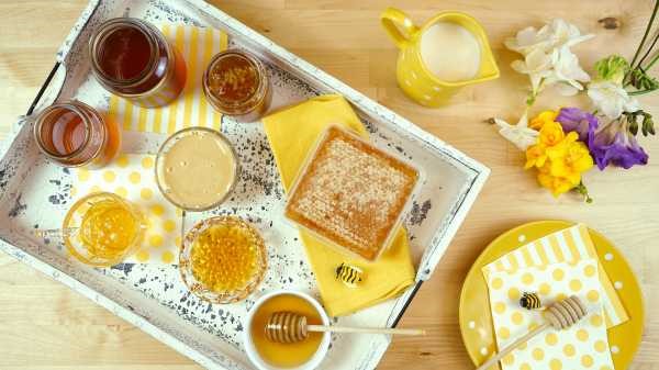 jars, pots and a block of comb honey arranged on a breakfast tray, with a napkin and small ornamental bee jars, pots and a block of comb honey arranged on a breakfast tray, with a napkin and small ornamental bee
