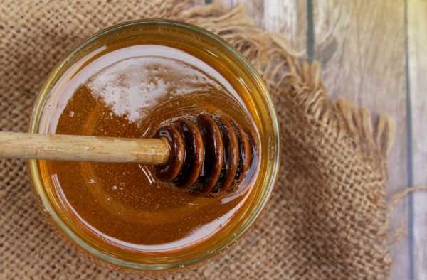 jar of clear honey on a piece of rustic hessian