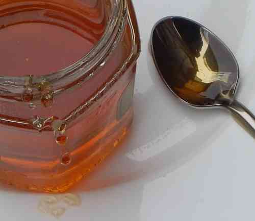 Honey and spoon on a plate Honey and spoon on a plate