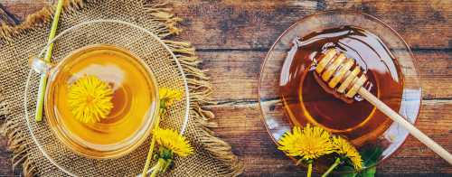 two glass bowls, one containing light honey and the other containing dark honey